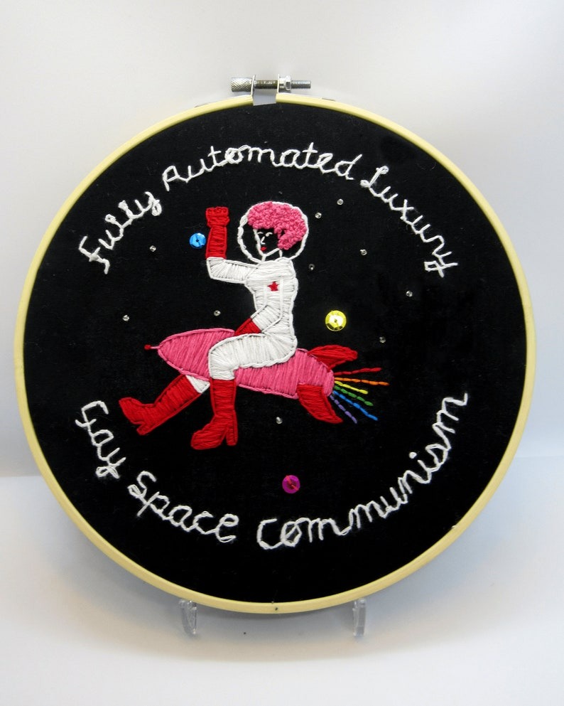 Fully Automated Luxury Gay Space Communism Embroidery Wall Art showing an image of an astronaut riding a rocket